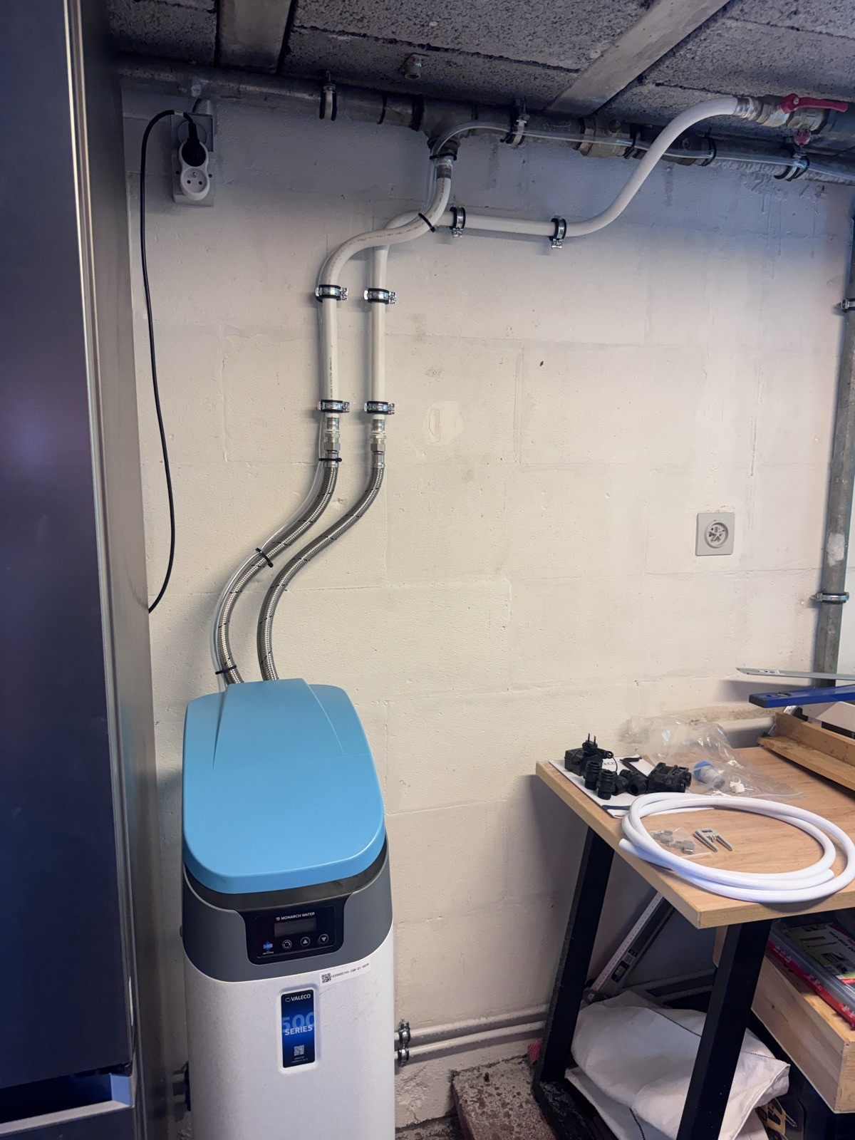Adoucisseur au sel Valeco 500 Series raccordé par flexibles inox dans le local technique d'une fermette à Manage