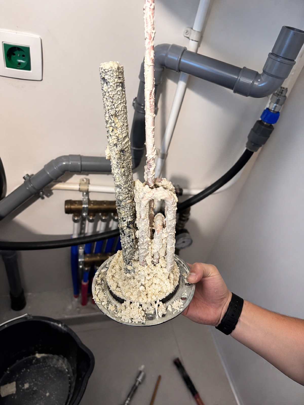 Résistance de boiler entièrement recouverte de calcaire, sortie de la cuve dans le local technique