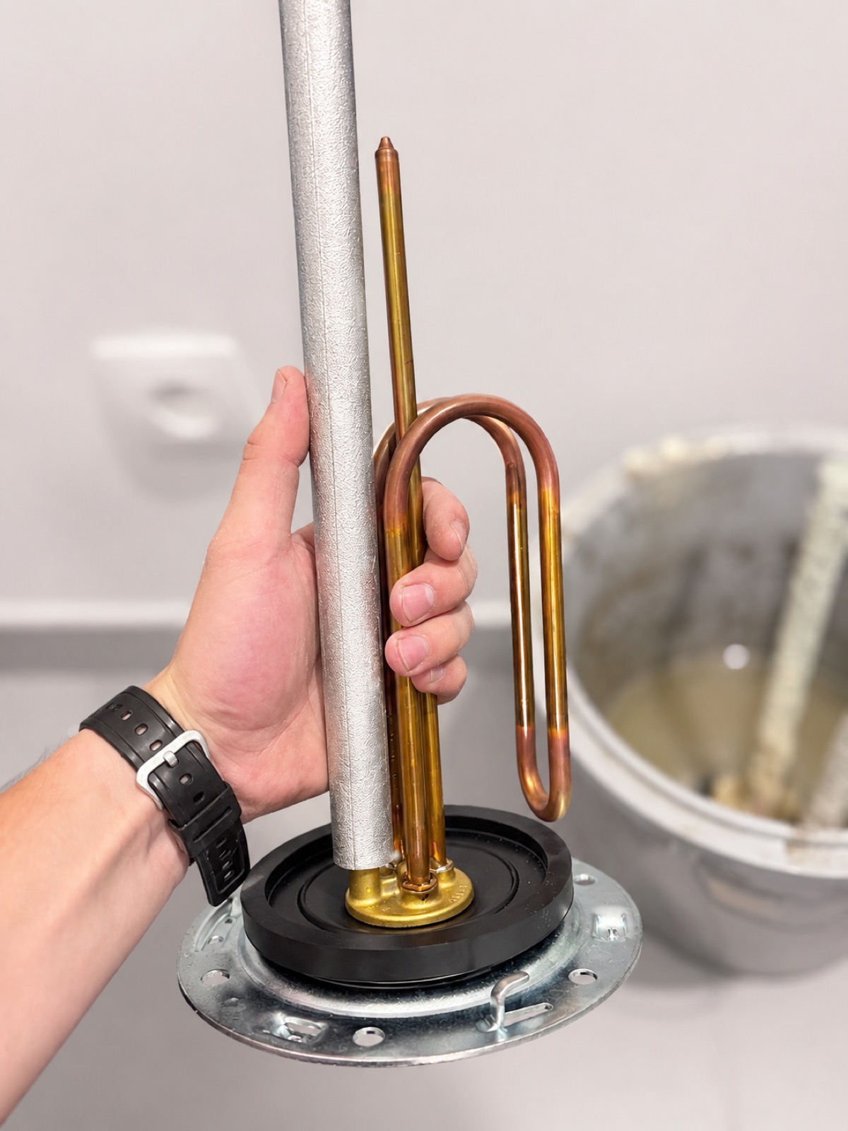 Résistance et anode neuves en cuivre prêtes à être posées, cuve du boiler ouverte à côté