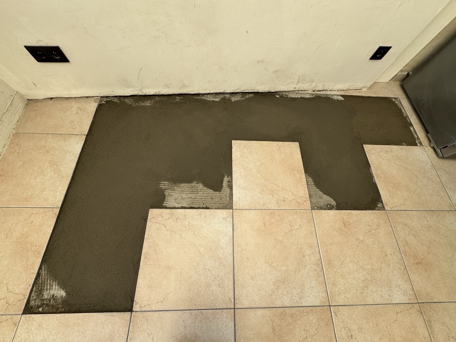 Tranchée rebouchée au stabilisé et à la chape, surface lissée au niveau du carrelage existant