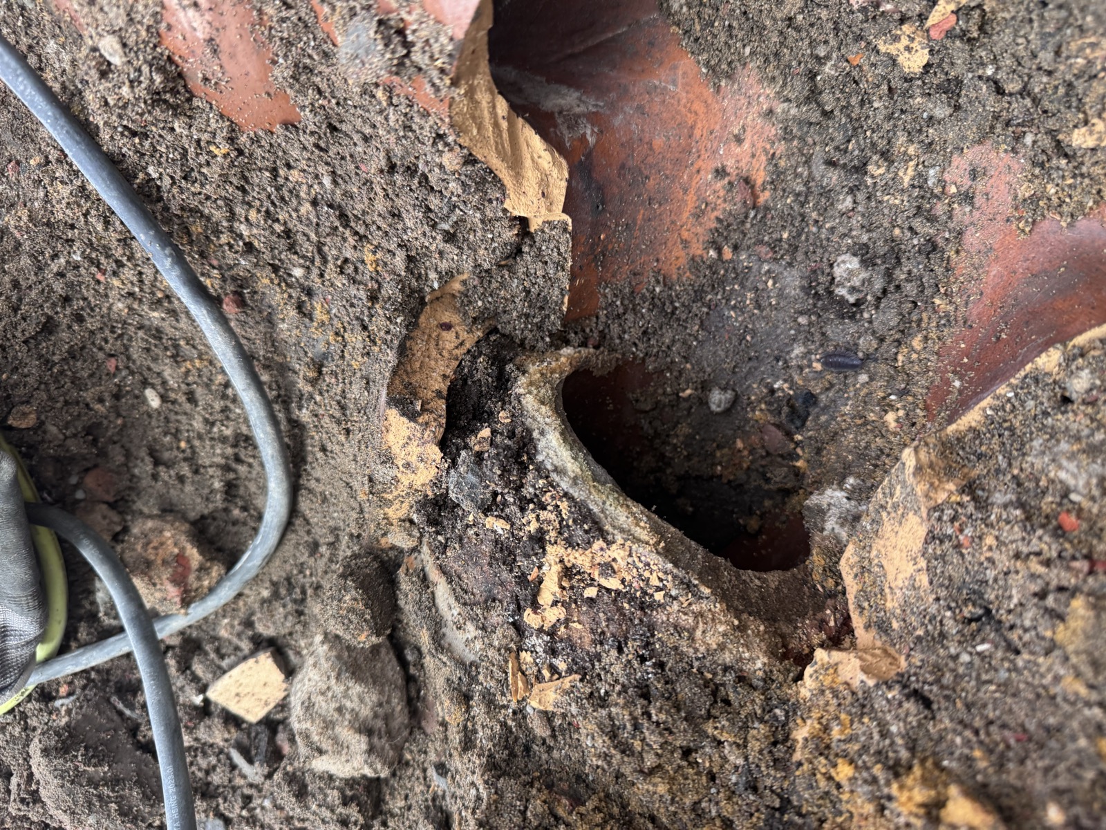 Emboîtement de l'ancien tuyau en grès cassé, ouverture béante laissant fuir l'eau